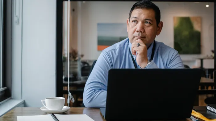 Emprendedor pensativo frente a su laptop en la oficina