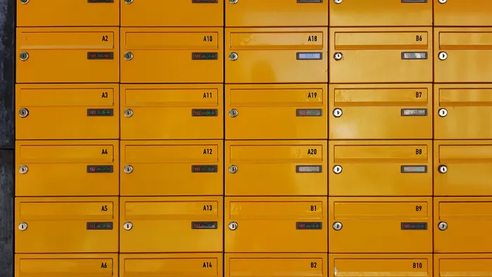 Pared de buzones de correo amarillos numerados, ordenados en cuadrícula