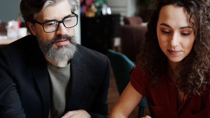 Dos profesionales revisando juntos la pantalla de una laptop durante una reunión