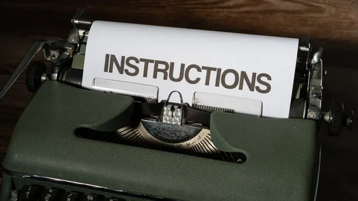 Máquina de escribir con una hoja en la que se lee la palabra «instructions»