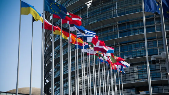 Banderas de los países de la Unión Europea ondeando frente al edificio del Parlamento Europeo